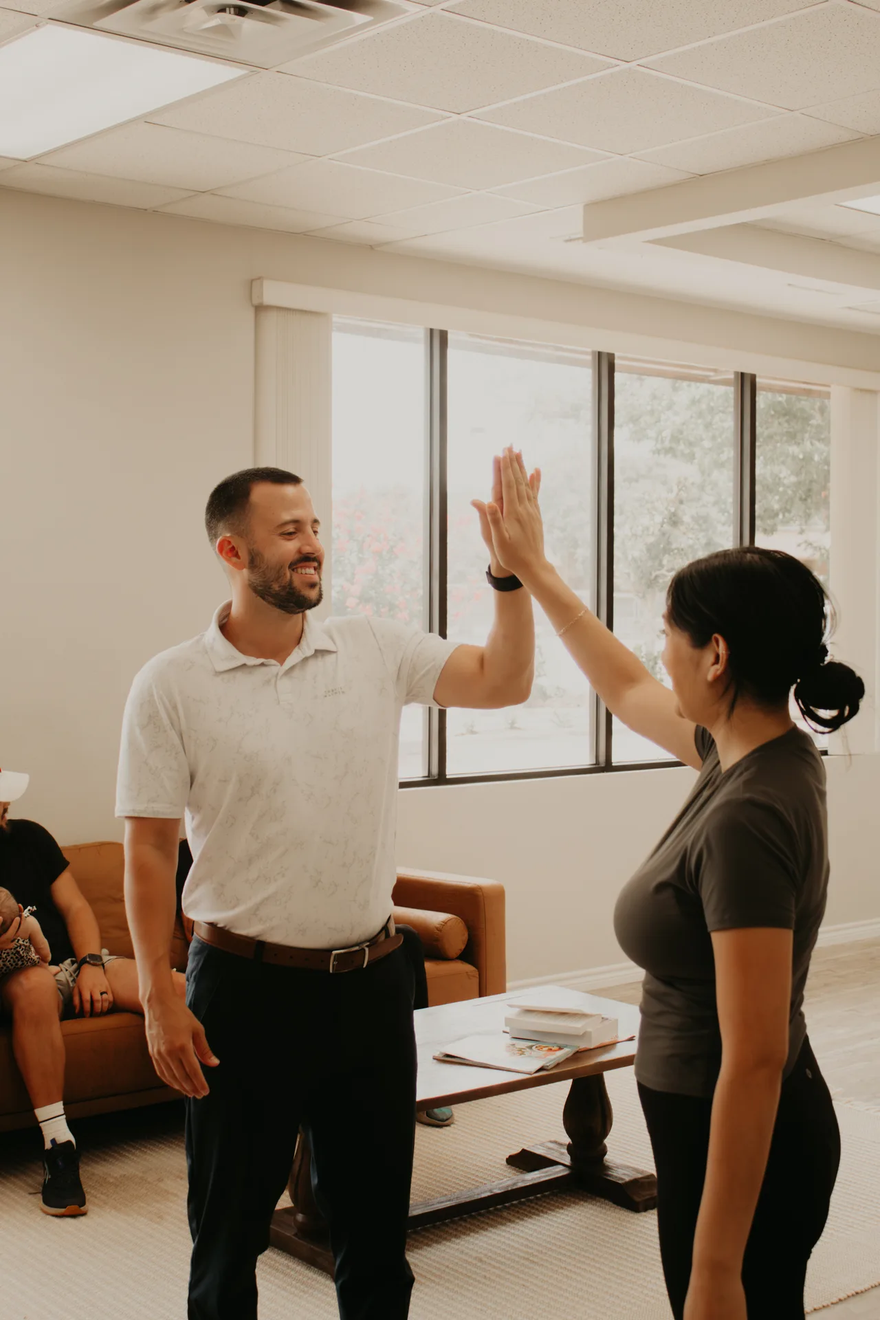 Dr. O'Brien high-fiving a young patient at Trinity Life Chiropractic in Allen, TX
